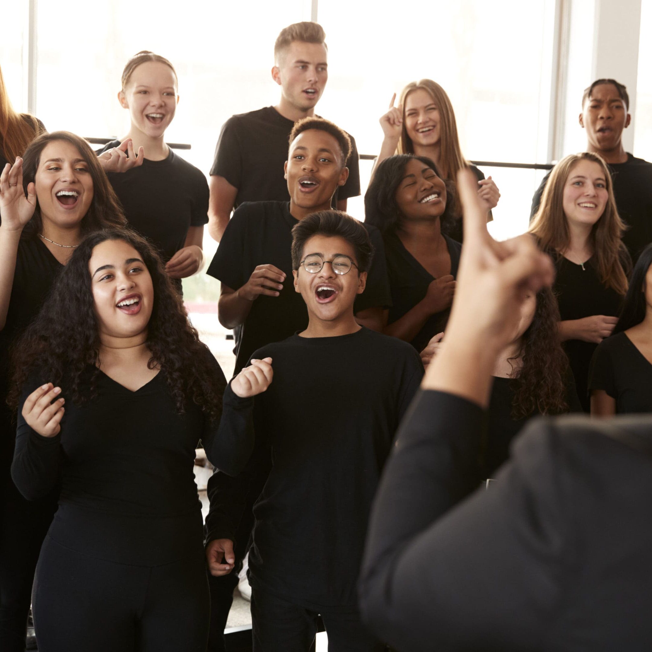 A group of people singing in front of a person.